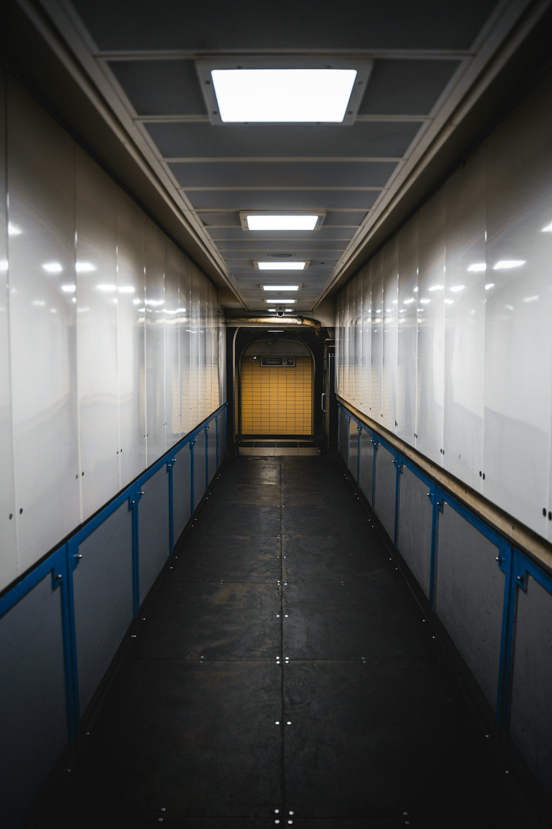 a long narrow hallway with a yellow door