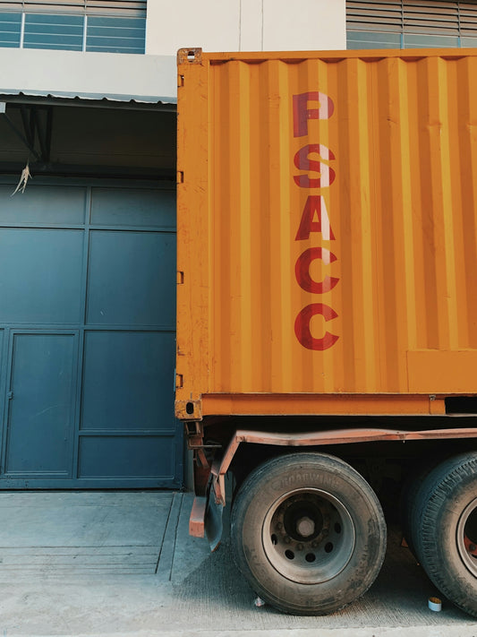 orange truck near white concrete house