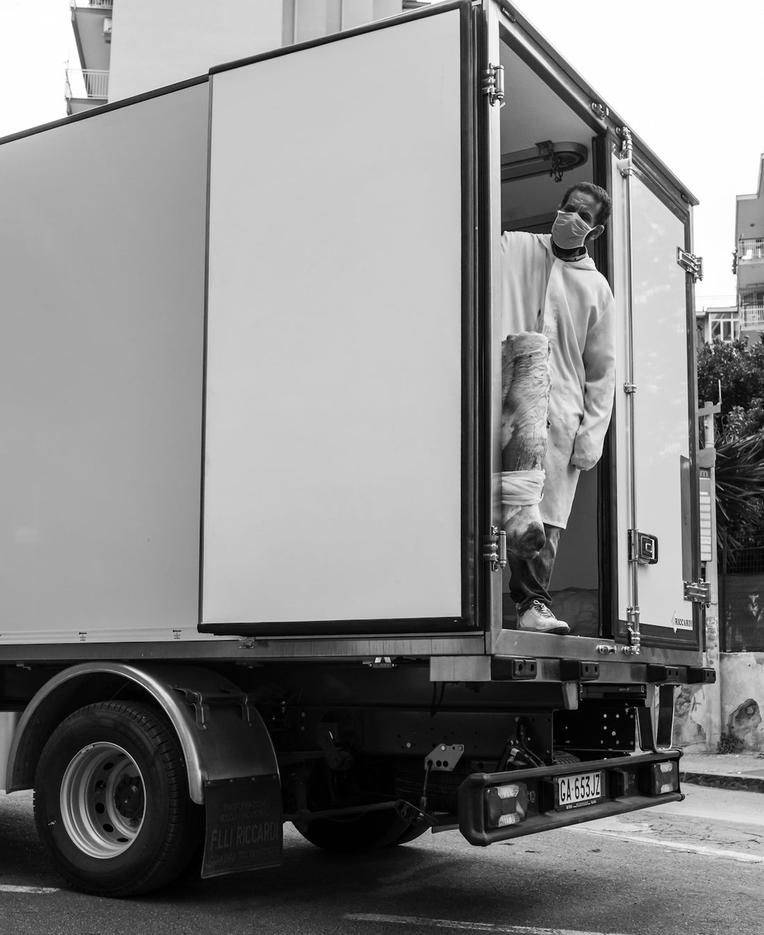 man in white dress shirt standing in front of truck