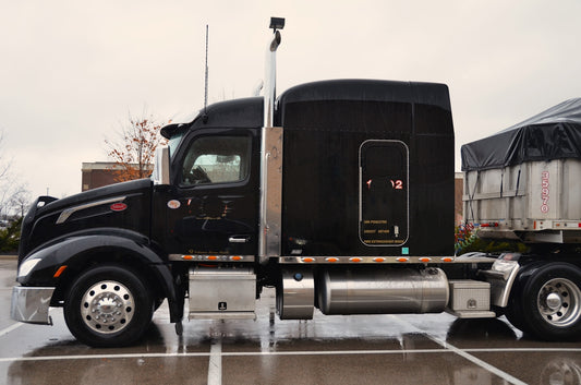 a black semi truck parked in a parking lot