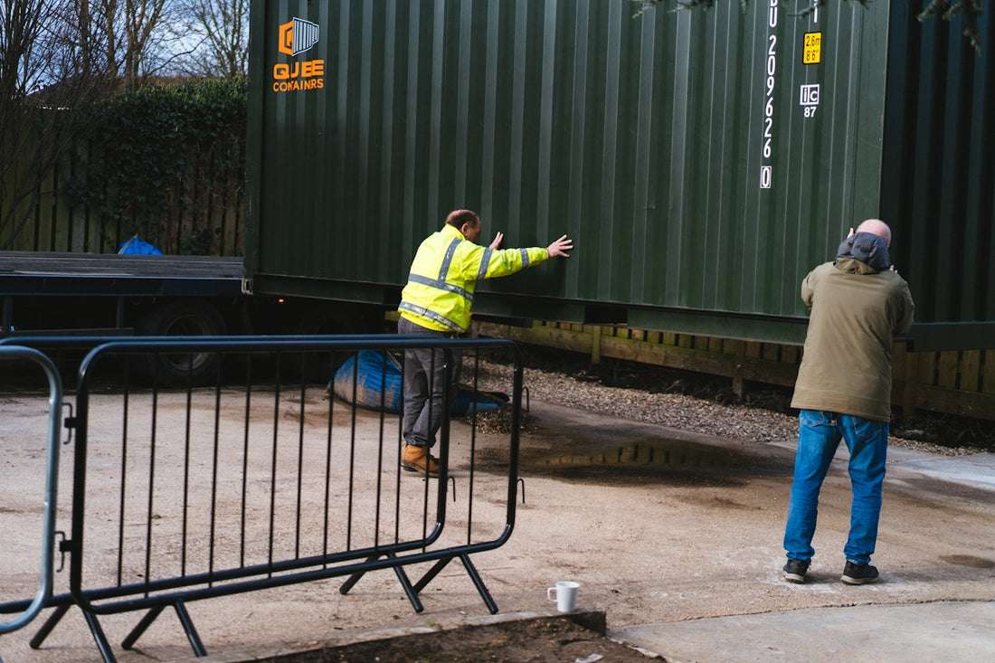 a couple of men standing next to a metal fence