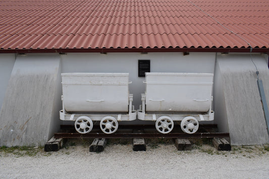 A train car sitting on top of a track next to a building