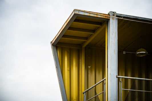 A modern structure's corner under a cloudy sky.