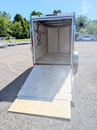 2026 American Hauler Arrow 5x8 Enclosed Cargo Trailer Pewter – rear ramp door fully open, OSB interior, smooth ramp surface