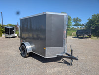 2026 American Hauler Arrow 5x8 Enclosed Cargo Trailer Pewter – rear passenger-side 3/4 view, ramp door closed, diamond plate stone guard