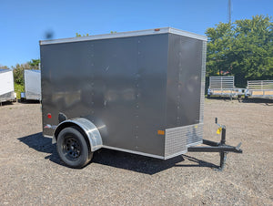 2026 American Hauler Arrow 5x8 Enclosed Cargo Trailer Pewter – driver-side 3/4 view, charcoal exterior, aluminum trim, black coupler