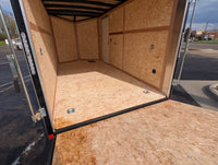 Interior view of 2026 Cargo Mate 7x14 enclosed cargo trailer showing Expo Cargo Plus package with 5000 lb recessed floor D-rings, 1200 lb recessed wall D-rings, LED dome lights, and 3/8 inch engineered wood walls