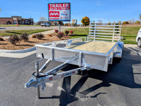A new Silver Ox tandem axle aluminum utility trailer with a rear ramp, displayed at a dealership lot.