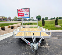 Silver Ox Aluminum utility trailer with wooden platform in front of a 'Trailer Sales & Parts' sign.
