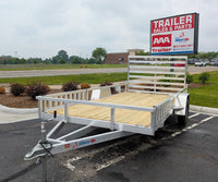 Silver Ox Aluminum utility trailer with wooden platform in front of a 'AAA Trailer Sales & Parts' sign.