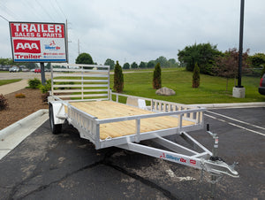 Silver Ox Aluminum  trailer with a wooden platform in front of a 'AAA Trailer Sales & Parts' sign.