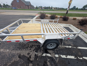 Utility trailer with wooden platform on a paved surface