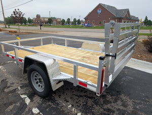 Silver Ox Aluminum trailer with wooden platform parked on a paved surface.