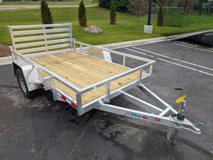 Silver trailer with wooden platform on a paved surface