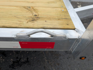 Metal gate with a wooden platform above it, showing a close-up of the gate's latch mechanism.