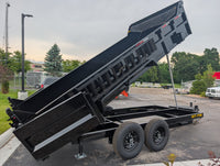 Black dump trailer with open bed in a parking lot