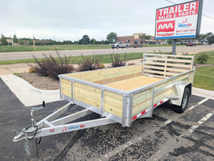 Silver Ox Wood side Aluminum utility trailer parked in a lot with a 'AAA Trailer Sales & Parts' sign in the background.