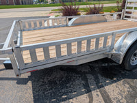 Side Ramps on Silver Ox Aluminum  trailer with wooden platform on a paved surface