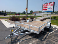 Silver Ox Aluminum trailer with wooden floor in a parking lot with a 'AAA Trailer Sales & Parts' sign in the background.