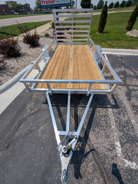 Small trailer with a wooden platform on a paved surface