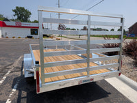 Silver utility trailer with wooden floor in a parking lot