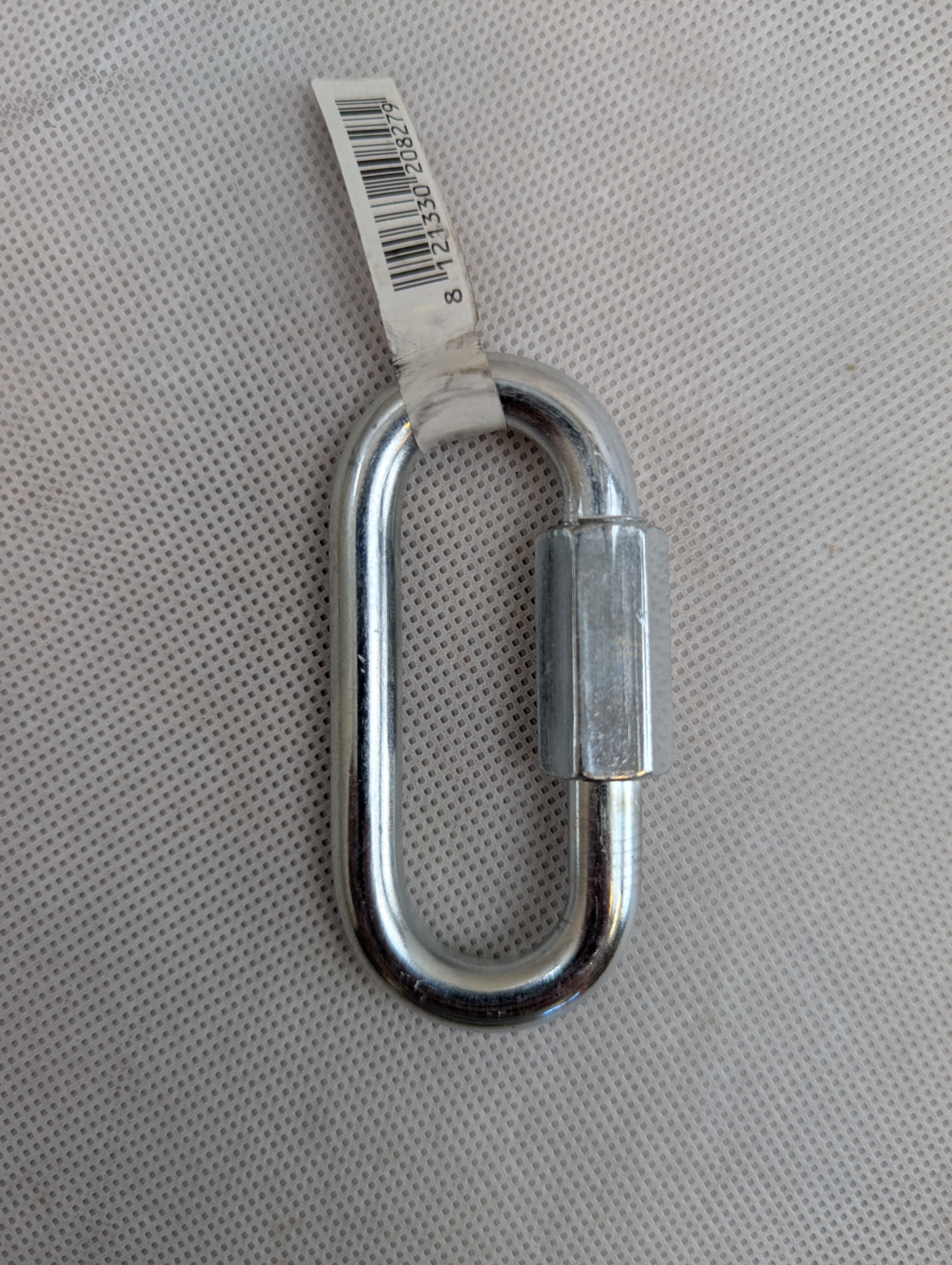 Metal carabiner with a label on a gray textured background