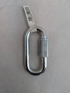 Metal carabiner with a label on a gray textured background