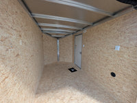 2026 AmeraLite Storm 6x10 interior looking toward V-nose — loading light wall switch, man door, OSB liner, aluminum roof extrusions visible