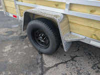 Silver Ox 6x12 Woody Trailer — axle and wheel closeup showing 205/75R15 radial ST tire on black mod wheel with diamond plate aluminum fender | AAA Trailer