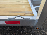 Silver Ox 7x10 Trailer — closeup of weld-on aluminum tie-down loop and DOT-C2 reflective tape on curbside rail