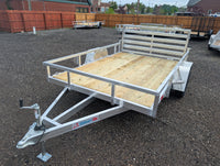 Silver Ox 7x10 Aluminum Utility Trailer with Folding Ramp Gate — driver-side full profile showing all-aluminum frame, treated wood deck and deployed folding gate | AAA Trailer Howell MI