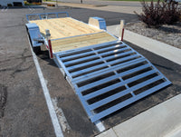 Silver Ox flat deck trailer with bi-fold aluminum ramp deployed on dovetail